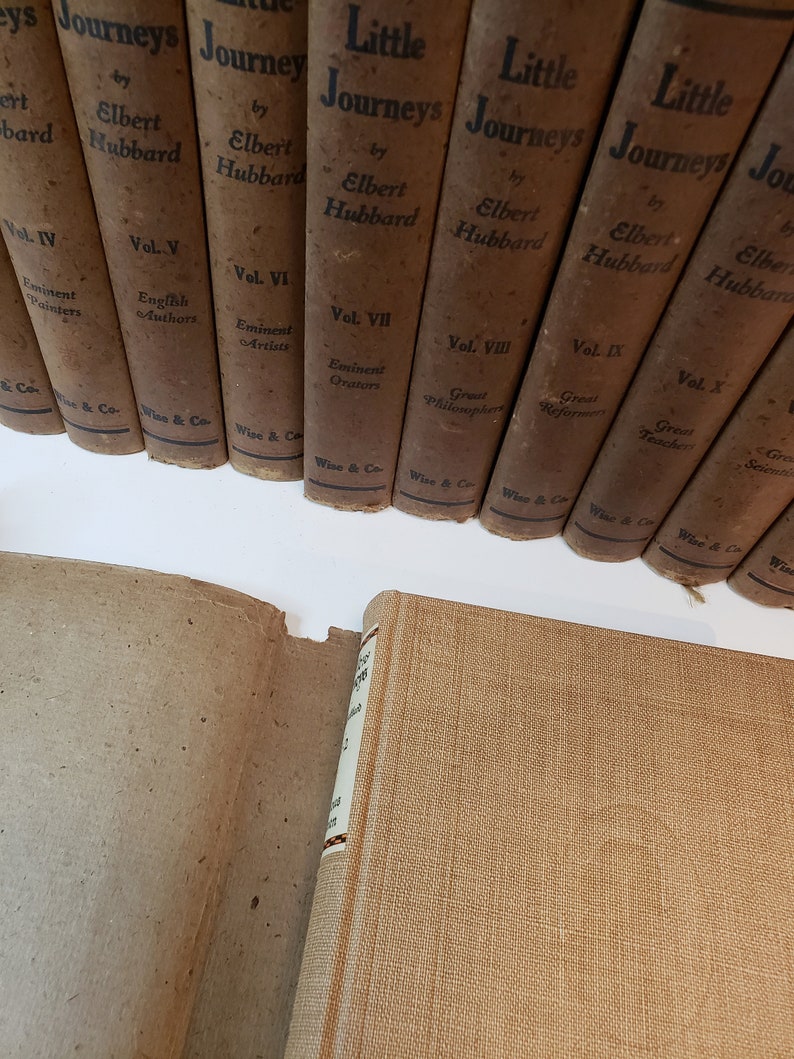 May include: A set of ten brown hardcover books titled "Little Journeys" by Elbert Hubbard. Each book features a different volume number and subject, such as "Eminent Painters", "English Authors", and "Great Philosophers".
