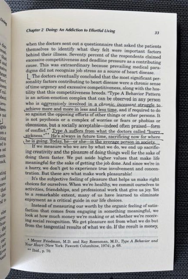 May include: Open book with text on a white page. The text is from a book chapter titled "Doing: An Addiction to Effortful Living." The page number 33 is visible. The book is on a dark gray surface.