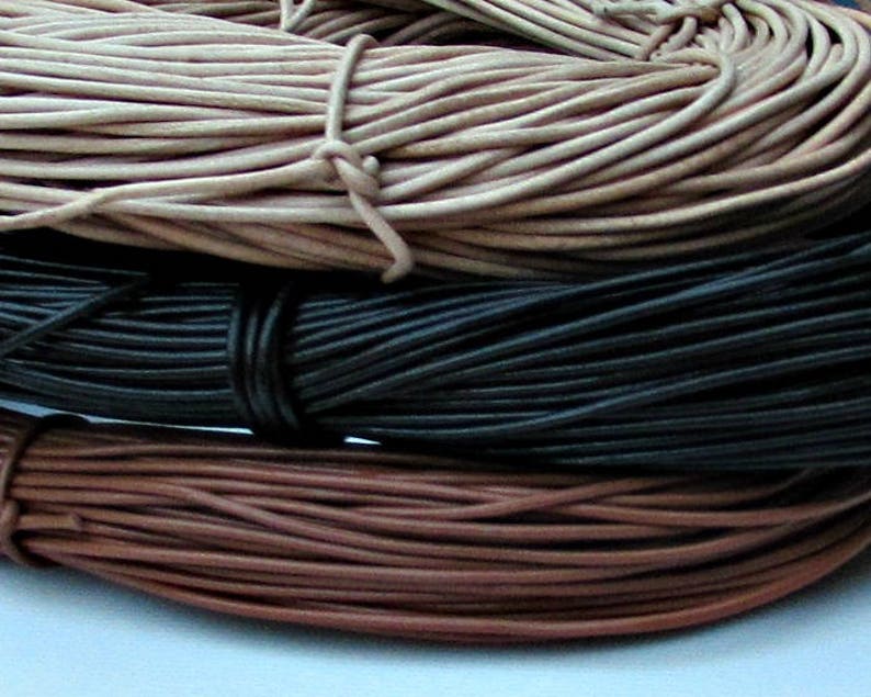 Puede incluir: Tres carretes de cord&oacute;n de cuero en diferentes colores: natural, negro y marr&oacute;n. Los cordones est&aacute;n enrollados apretados y listos para ser utilizados en proyectos de artesan&iacute;a.