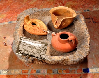 May include: Three terracotta oil lamps with wicks, a small bowl, and a bundle of wicks in a stone bowl.