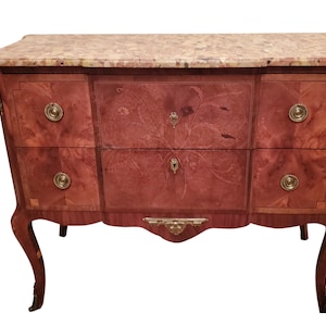May include: A vintage wooden chest of drawers with a marble top. The chest has four drawers with brass handles and intricate marquetry details. The legs are curved and the chest is painted in a rich mahogany color.
