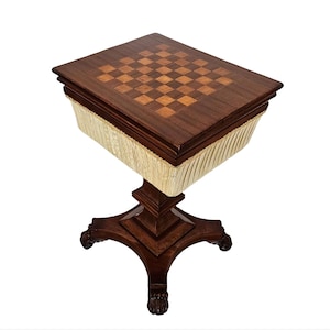 May include: A dark wood game table with a checkered top and a white fabric lining. The table has a pedestal base with four legs.
