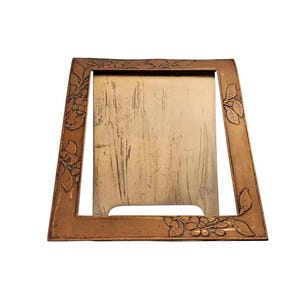 May include: A vintage, ornate picture frame with a carved floral design. The frame is made of wood and has a brown finish.