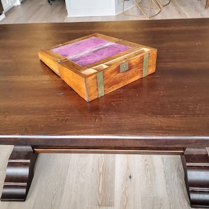 May include: A wooden writing box with a hinged lid and a purple velvet interior. The box has brass accents and a small keyhole.