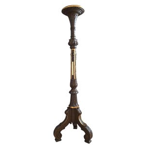 May include: Ornate, dark brown floor lamp with a decorative, carved design. The lamp features a wide, circular top and a three-legged base. Gold accents highlight the intricate details of the lamp's design. The lamp is a decorative home decor item.