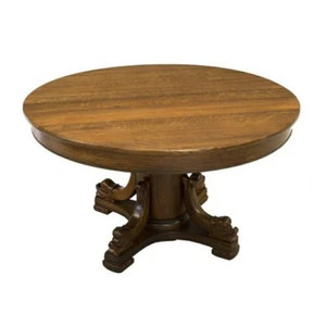 May include: A round wooden table with a dark brown finish. The table has a pedestal base with four carved legs that resemble animal paws.