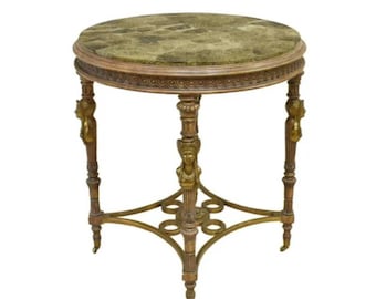 May include: A round antique side table with a green marble top. The table has ornate, carved wooden legs with gold accents and a decorative base. The table is approximately 24 inches in diameter and 28 inches tall.