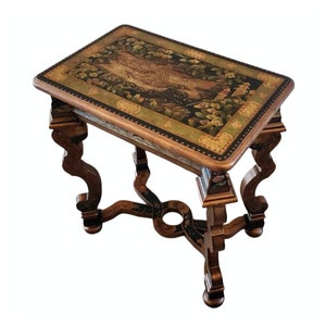 May include: A small, rectangular table with a hand-painted top featuring a floral design and a bird. The table has four intricately carved legs with a black and gold finish.