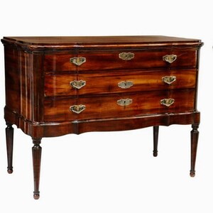 May include: A three-drawer chest with a mahogany finish and brass hardware. The chest has a curved top and sits on four slender legs.