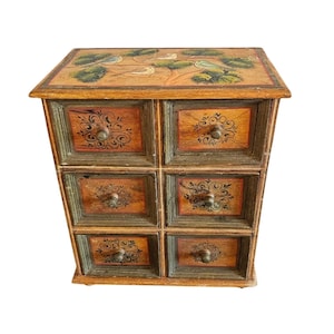 May include: A wooden chest with six drawers, each with a painted floral design and a brass knob. The top of the chest is painted with a scene of birds in a tree.