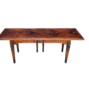 May include: A dark wood table with a geometric inlay pattern on the top. The table has four legs with carved details and a rectangular shape.