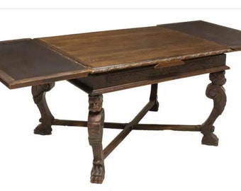May include: A dark brown wooden table with intricate carvings on the legs and a drop-leaf design. The table has a rectangular top and a cross-shaped base.