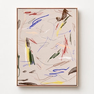 May include: A rectangular framed wall art piece featuring a light beige background with scattered, multi-colored crayon-like scribbles in blue, red, yellow, dark green, brown, and white, contained within a thin, light-toned wooden frame.