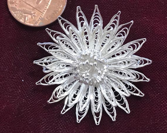 A beautiful vintage silver filigree flower brooch