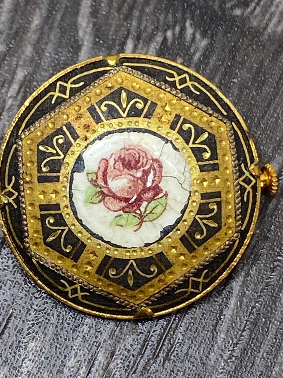 A Vintage Spanish Damascene black and gold brooch with enamelled rose center