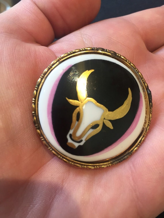 Vintage hand painted ceramic brooch by Rosenthal of Germany. It features the zodiac sign of the bull ( Taurus).