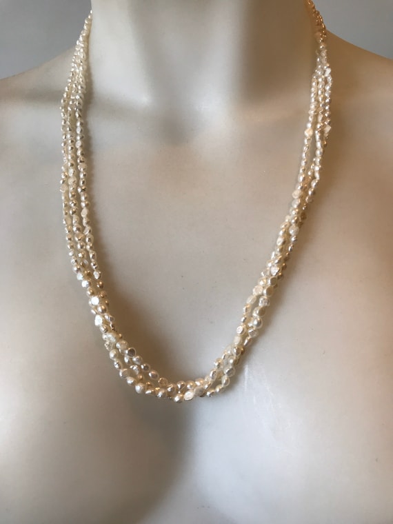A striking long length 24 inch vintage beaded 3 stranded creamy white cultured baroque rice pearl necklace