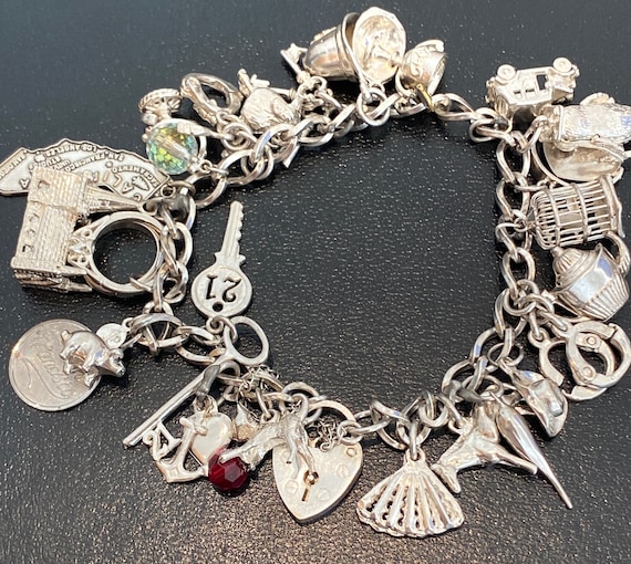 Lovely vintage Heavy solid silver charm bracelet with 25 mixed silver some rare moving charms 49.3 grams in weight