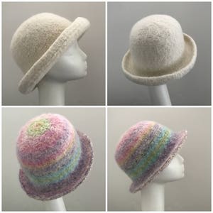 May include: Four crocheted hats, two white and two with a rainbow pattern. The hats are displayed on mannequins.