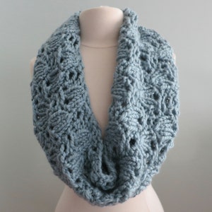 Könnte beinhalten: Ein hellblauer gestrickter Infinity-Schal mit einem zarten Lochmuster.