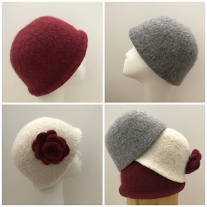 May include: Four felt hats in different colors and styles. One hat is burgundy, one is gray, one is white with a burgundy flower, and one is a stack of gray, white, and burgundy hats.