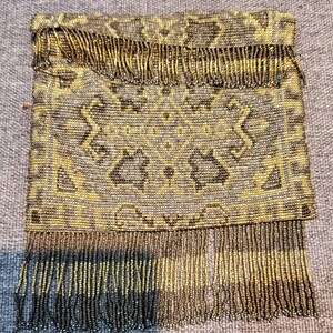 May include: A vintage beaded purse with a geometric pattern and a fringe border. The purse is made of gold and silver beads.