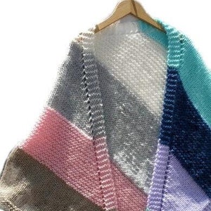 May include: A knitted shawl with stripes of pink, gray, white, blue, and teal.