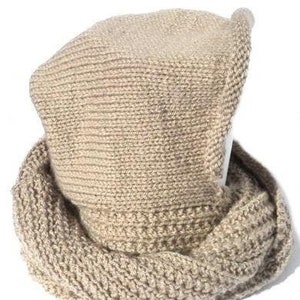 May include: A beige knitted hat with a folded brim and a matching scarf. The hat and scarf are made of a soft, textured yarn.