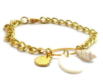 Gold-colored bracelet with a goldplated metal charm and 2 shell charms. Handcrafted wristlet with gold colored chain links, closure, charm