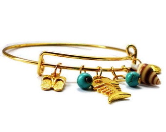 Gold colored metal bracelet with charms. Handmade wristband, bangle wristlet, arm jewelry beachlife, natural stone, shell, sandal, fishbone