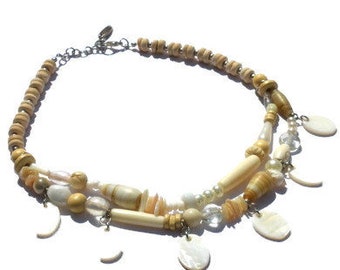 Necklace with beads of ceramic, shell, mother-of-pearl, glass, coconut, bone in beige and off-white. Double strand collar with shell charms