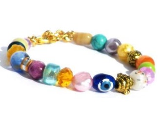Armband met kralen in verschillende kleuren en goudkleurige kralen. Handgemaakte polsband, kralen glas, keramiek, boos oog, Per Elle