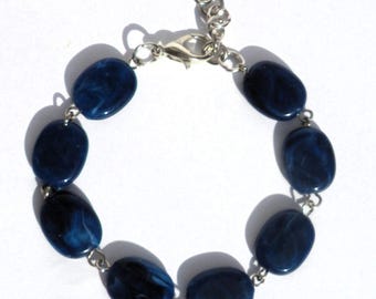 Dark blue bracelet with resin beads in flat and oval shape. Handcrafted boho wristband, jewelry handmade in Europe, silver-colored accents