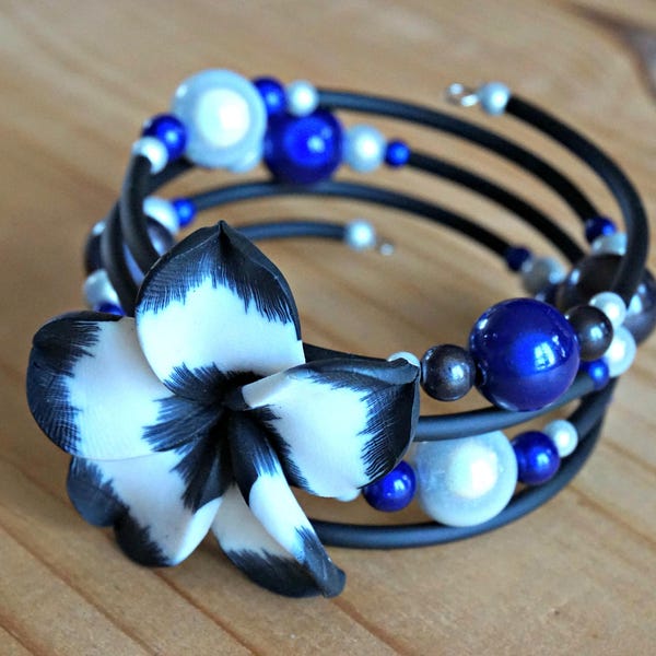 Bracelet avec fil mémoire. Fleur de polymère blanche et noire et tube de caoutchouc. Couleur blanc, bleu et noir. Bijoux bleu pour femme