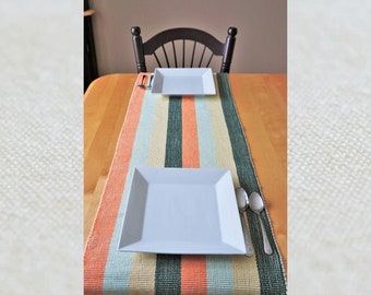 Large rectangular placemat for 2, hand-woven (green, orange, yellow). Weaving with bangs and stripes. Set of table for lunch, table center