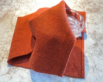 100% cotton handwoven dishcloth with zebra pattern , in orange and black colors . Hand woven on a traditional loom.