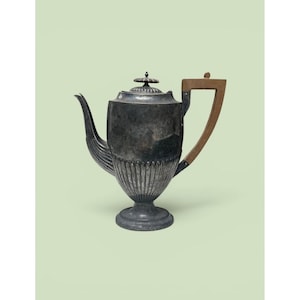 May include: A silver-toned metal teapot featuring a fluted lower body, a curved spout, and a flat-topped lid with a small finial. The teapot includes a distinct angular handle made of light brown wood, attached to the main body with metal hardware.
