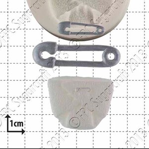 Peut inclure: Un moule en silicone blanc avec trois formes d'épingles de sûreté. Le moule mesure 1 cm et est conçu pour faire des décorations de gâteaux.