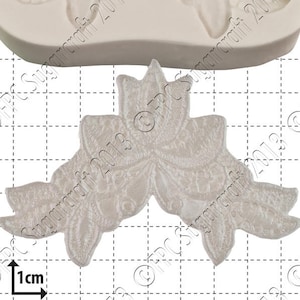 May include: A silicone mold for baking, featuring a design of three stylized flowers. The mold is white and measures 1 cm in diameter.