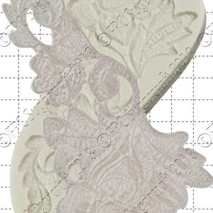 May include: A white silicone mould with two floral designs. The mould is 1 cm wide and features intricate details.