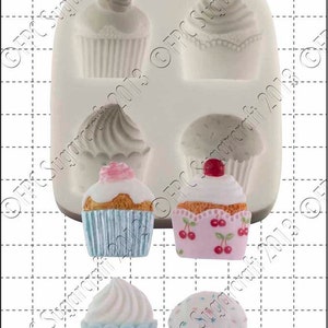 Puede incluir: Molde de silicona para hacer seis cupcakes. El molde tiene dos filas de tres cavidades para cupcakes. Las cavidades tienen forma de cupcakes con glaseado y chispas. El molde es blanco y tiene una escala de medición de 1 cm.