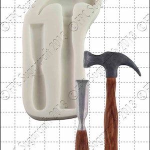 May include: A white silicone mould with hammer and chisel impressions, next to a painted hammer and chisel. The hammer has a grey head and a brown wooden handle. The chisel has a silver blade and a brown wooden handle. The scale shows 1 cm.