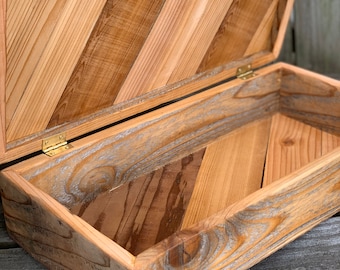 May include: Open wooden box with a hinged lid. The box is constructed from light and dark brown wood planks arranged in a diagonal pattern. The interior is visible, and the box is empty. The hinges are brass-colored.