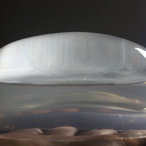 May include: A clear, dome-shaped silicone mold for making resin crafts. The mold is sitting on a clear, flat base.