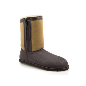 May include: Brown leather winter boots with a zipper up the side and a tan suede panel. The boots have a sheepskin lining.