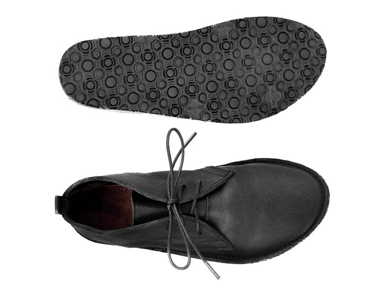 Puede incluir: Botas de tobillo de cuero negro con cordones. Las botas tienen una suela de goma texturizada.