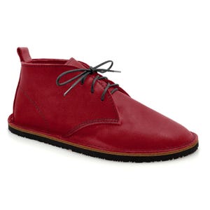 May include: Red leather ankle boots with black laces and a brown rubber sole.