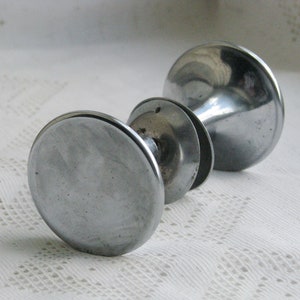 Może przedstawiać: Srebrny klamka do drzwi z okrągłym uchwytem i ozdobną podstawą.