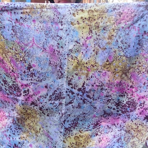 May include: A colorful fabric with a tie-dye pattern in shades of blue, pink, purple, and brown. The fabric has a mottled, textured appearance.