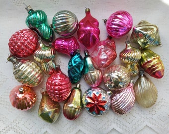 May include: A collection of vintage glass Christmas ornaments in various colors and shapes, including red, pink, green, gold, and blue. The ornaments have a variety of textures, including ribbed, textured, and smooth.
